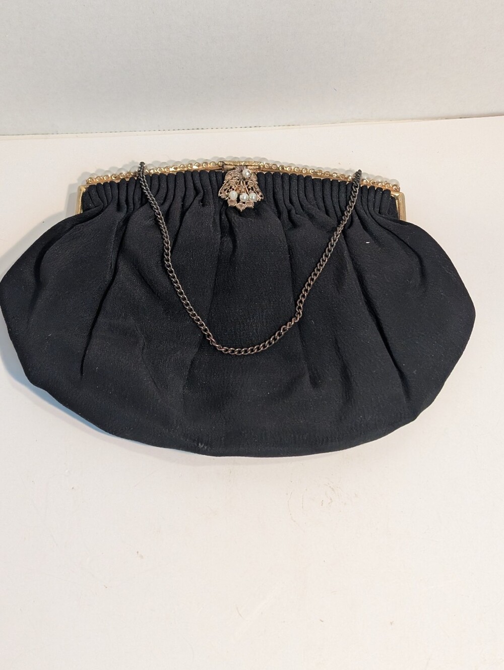 A Vintage evening bag features a black fabric design.